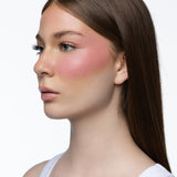 Model wearing MINË Plumping Blush Stick in Pinky Promise