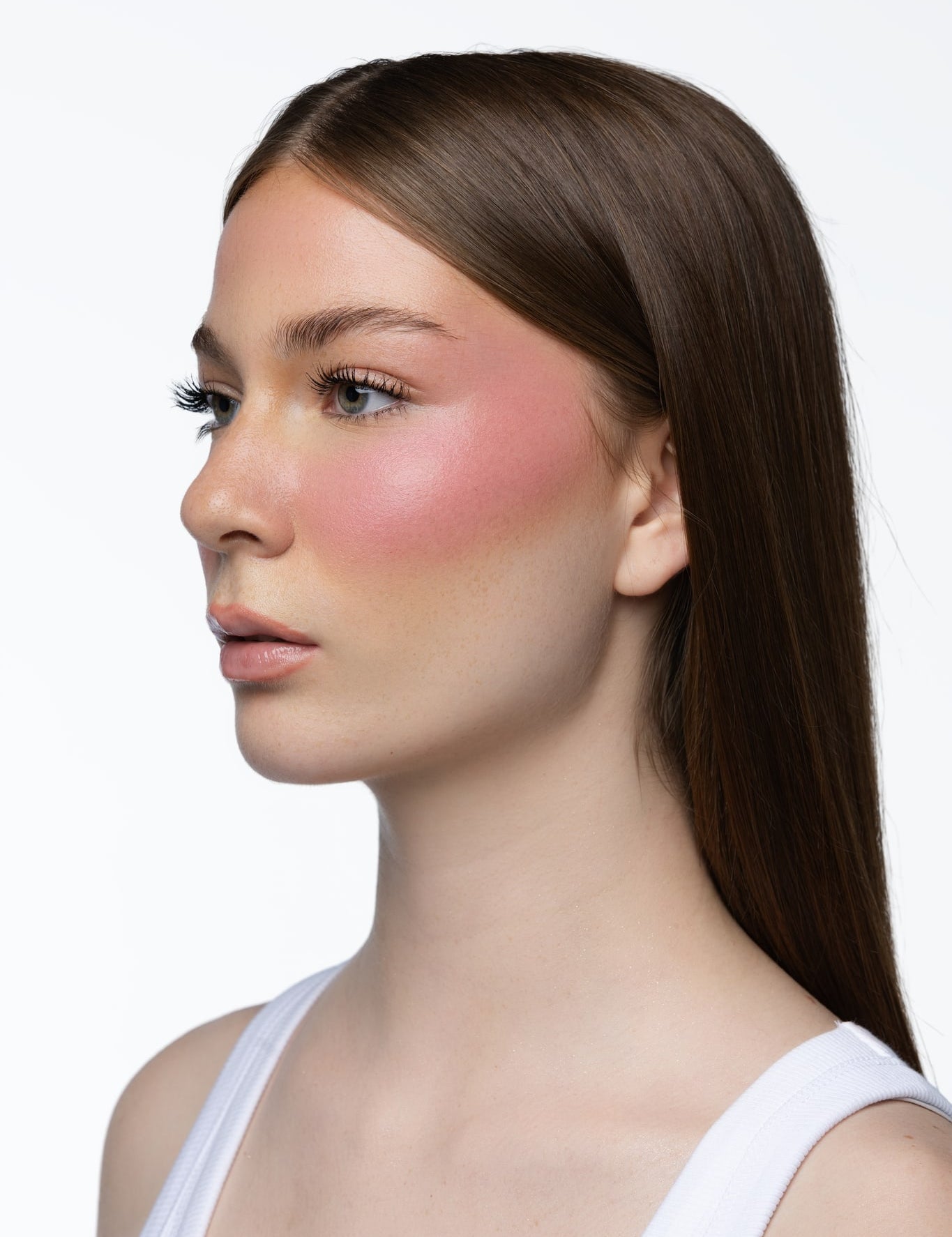 Model wearing MINË Plumping Blush Stick in Pinky Promise