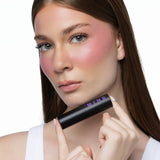 MINË Plumping Blush Stick in Pinky Promise held by model
