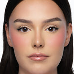 Model wearing MINË Plumping Blush Stick in Peach Melt