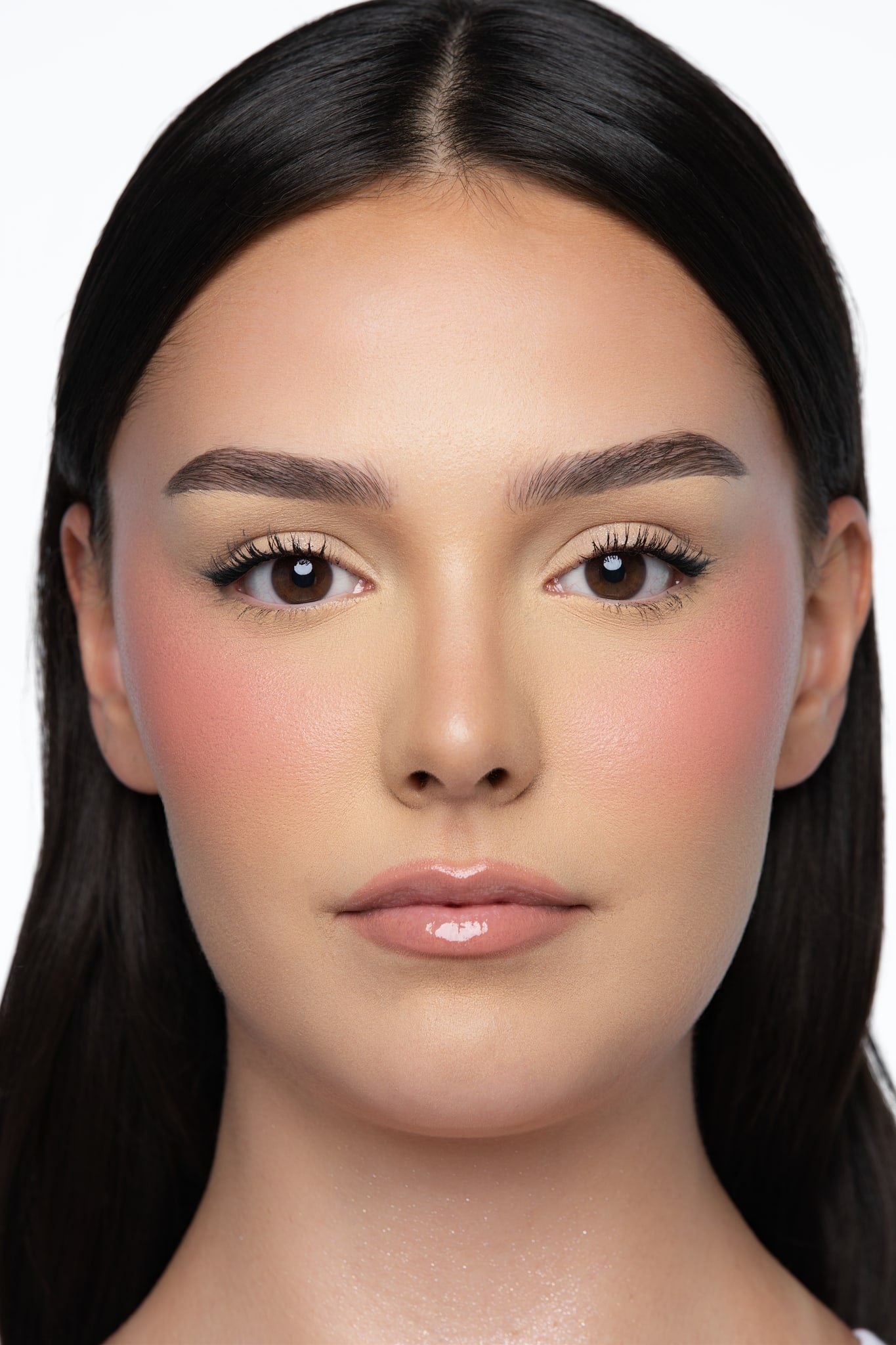 Model wearing MINË Plumping Blush Stick in Peach Melt