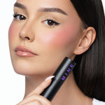 MINË Plumping Blush Stick in Peach Melt held by model