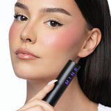 MINË Plumping Blush Stick in Peach Melt held by model